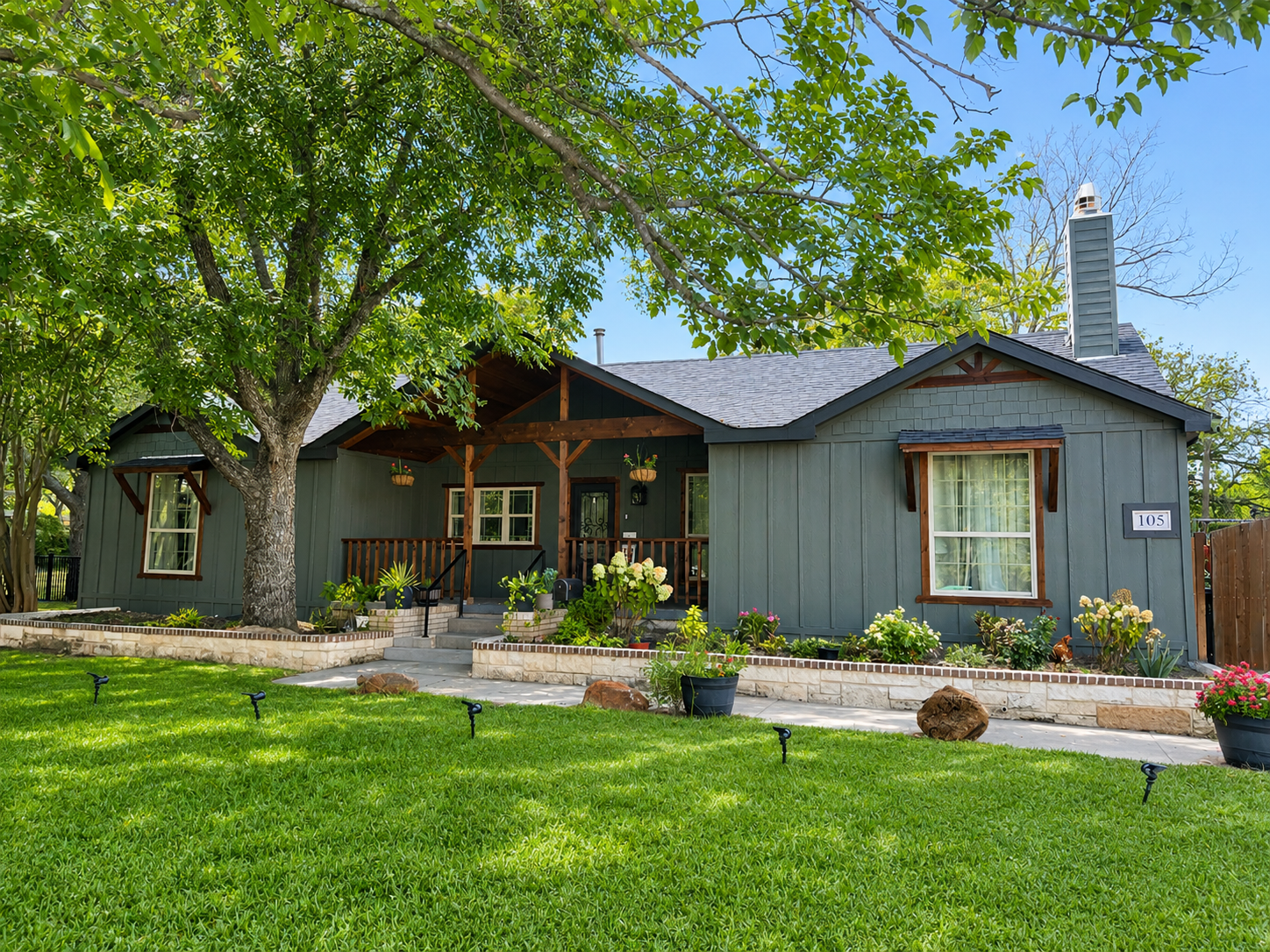 Finished exterior paint job, sage-green home with covered porch