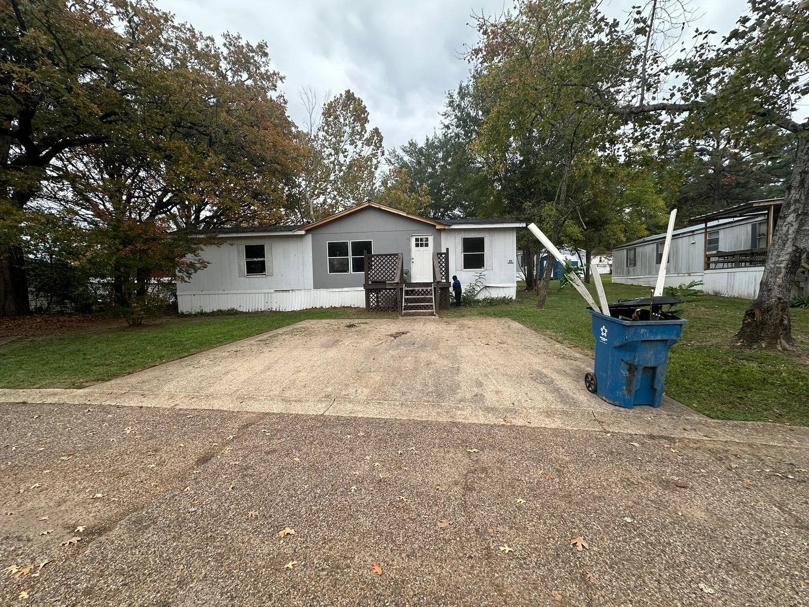 Mobile home mid-remodel with fresh gray paint and a new deck